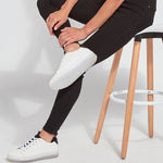 color=Black, Seated side view of black,  toothpick denim jean leggings with patented concealed waistband, seen from waist down